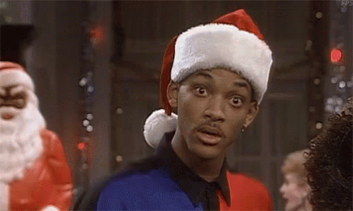 Man in Santa Hat Before Santa Claus Statue