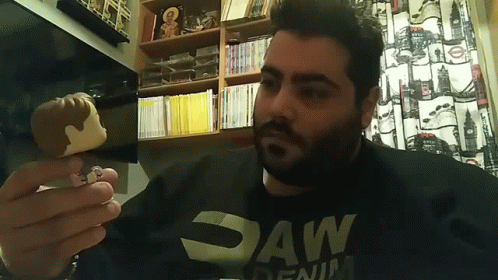 Man in Saw Denim Shirt Holding Pop Figure