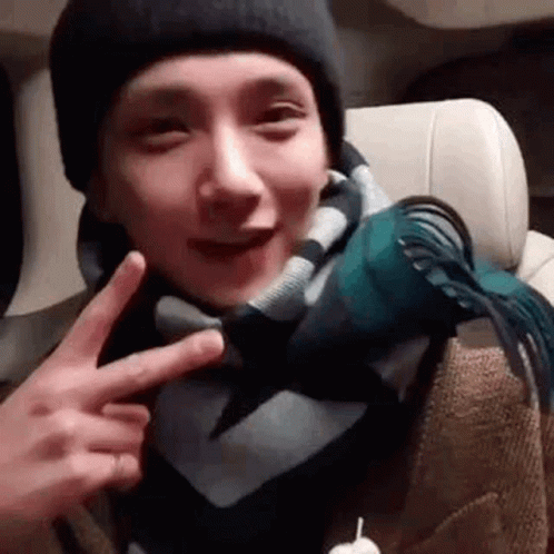 Man in Scarf and Hat Giving Peace Sign
