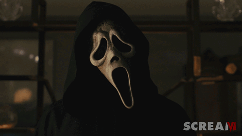 Man in Scream Costume With Have At Banner