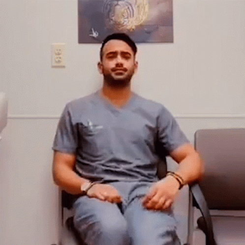 Man in Scrubs Cross-Legged Next to Tiger Picture