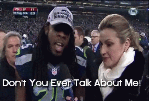 Man in Seahawks Hat with Woman Saying Don't You Ever Talk About Me