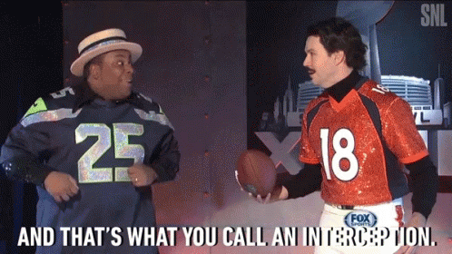 Man in Seahawks Jersey Talking to Man in Orange Jersey Number 18