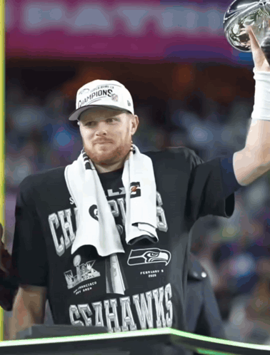 Man in Seahawks T-Shirt Holding Trophy