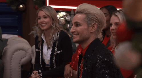 Man In Sequined Jacket Smiling Next To Woman GIF