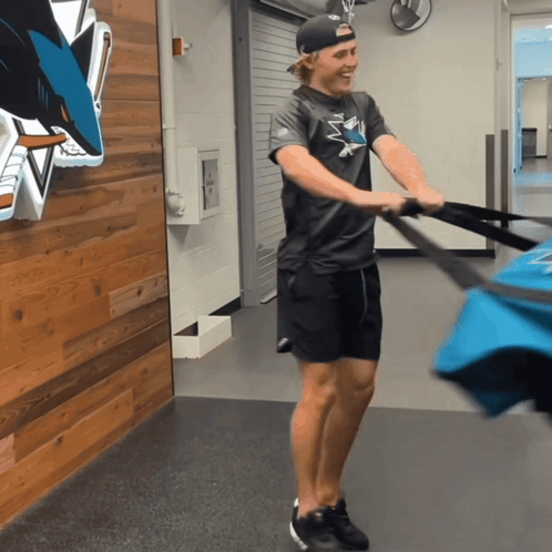Man in Sharks Shirt Pulling Bag