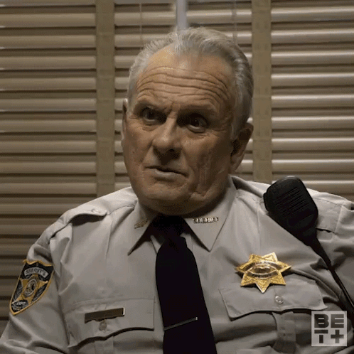 Man in Sheriff's Uniform Sitting by Shutters