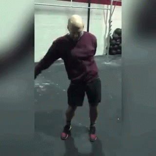 Man In Shorts And Red Sweater Dancing In Gym GIF