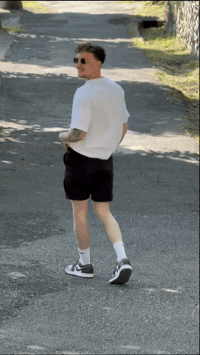 Man in Shorts and White Shirt Walking