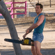 Man In Shorts Holding Chainsaw GIF