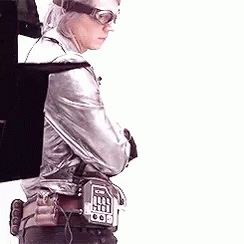 Man in Silver Jacket and Goggles Holding Gun With Arms Crossed