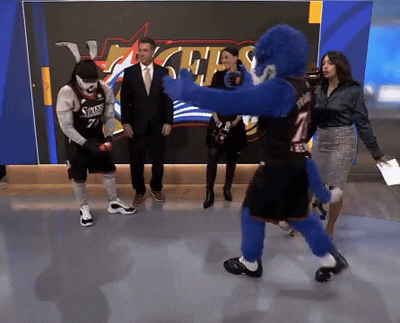 Man In Sixers Jersey Standing In Front Of 76Ers Sign GIF