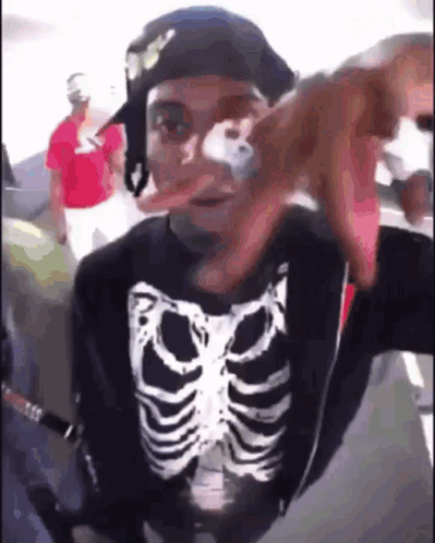 Man in Skeleton Shirt and Hat Taking Selfie on Plane