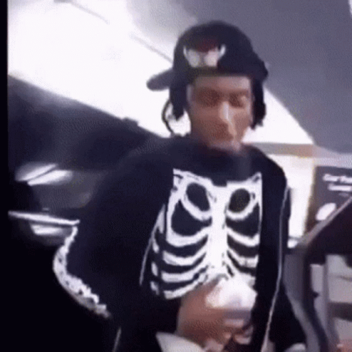 Man in Skeleton Sweater and Hat Holding Cup