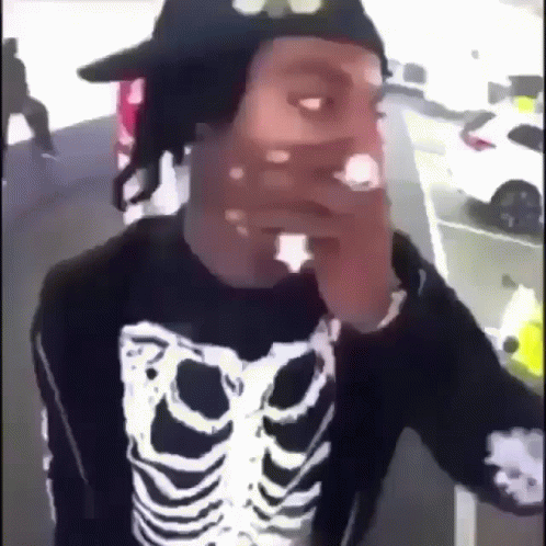 Man in Skeleton Sweater and Hat Smoking Cigarette