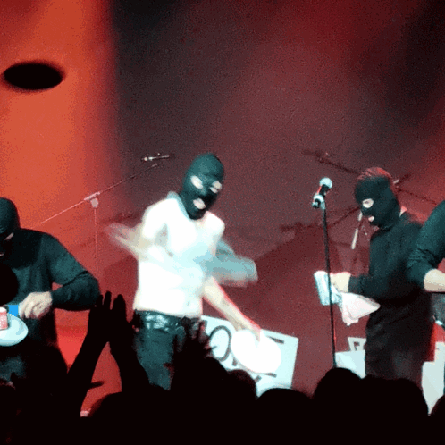 Man in Ski Mask Playing Drums on Stage