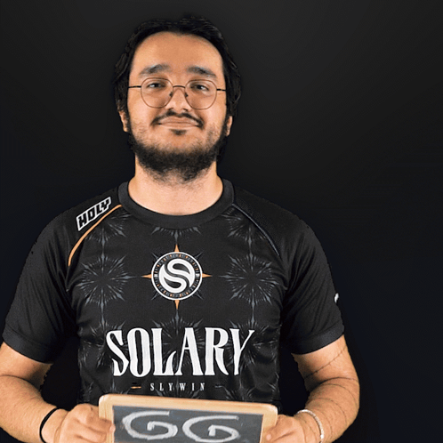 Man in Solary Shirt Holding Chalkboard Saying GG