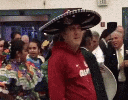 Man in Sombrero and Red Shirt in Front of Crowd