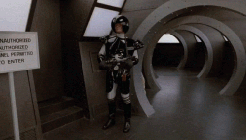 Man in Space Suit Near Authorized Tunnel Sign