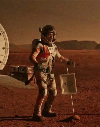 Man in Space Suit Next to Yes Sign