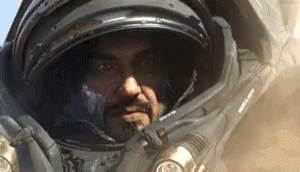 Man in Space Suit with Helmet Looking at Camera