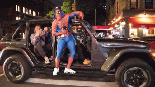 Man in Spider-Man Costume Standing in Jeep