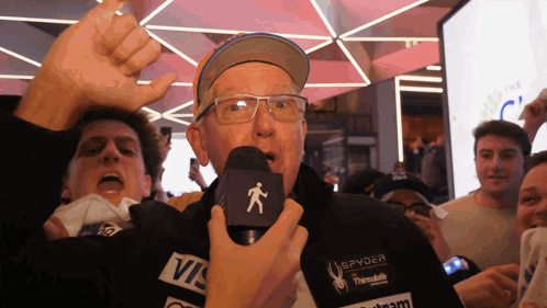 Man in Spyder Jacket Holding Microphone Before Crowd