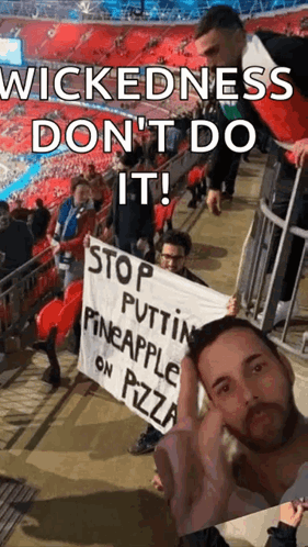 Man in Stadium Holding Wickedness Sign