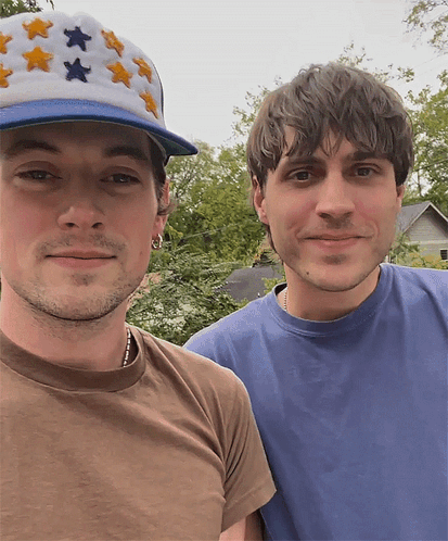 Man in Star Hat Next to Man in Blue Shirt