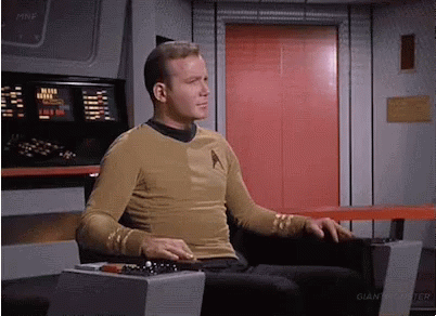 Man in Star Trek Uniform Sitting in Front of Red Door