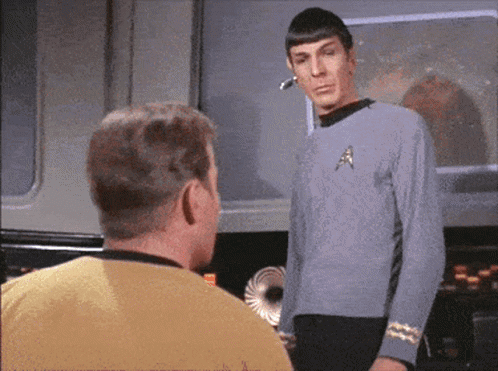 Man in Star Trek Uniform Talking to Man in Yellow Shirt