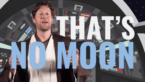 Man in Star Wars Costume in Front of Sign Saying That's No Moon