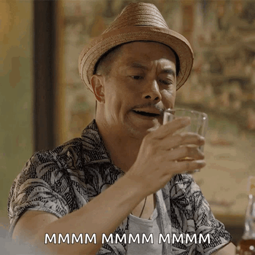 Man in Straw Hat Drinking Glass Saying Mmm