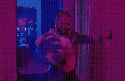 Man in Striped Jacket Under Purple Lights