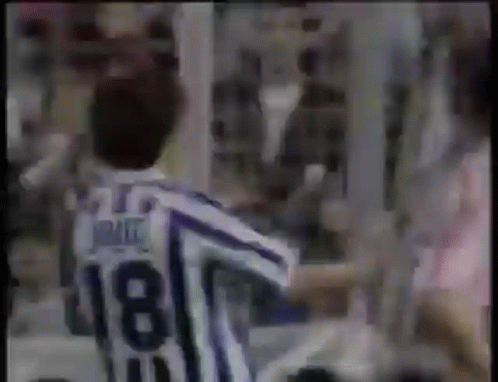 Man in Striped Jersey Number 18 in Front of Crowd