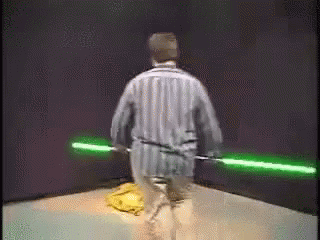 Man in Striped Pajamas Holding Green Lightsabers