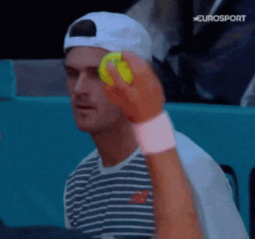 Man in Striped Shirt Holding Tennis Ball