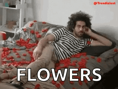 Man in Striped Shirt Laying on Rose Petals With Word Flowers