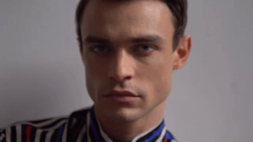 Man In Striped Shirt Looking At Camera GIF