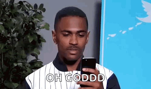 Man in Striped Shirt Looking at Cell Phone