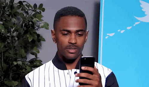 Man In Striped Shirt Looking At Cell Phone GIF