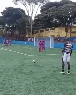 Man in Striped Shirt on Soccer Field with Ball