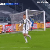 Man in Striped Shirt Running Towards Soccer Goal