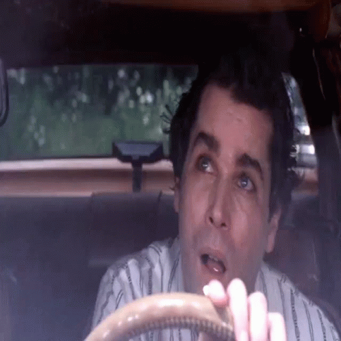 Man in Striped Shirt Sitting in Car With Mouth Open