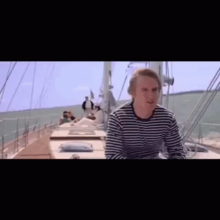 Man In Striped Shirt Sitting On Boat In Ocean GIF