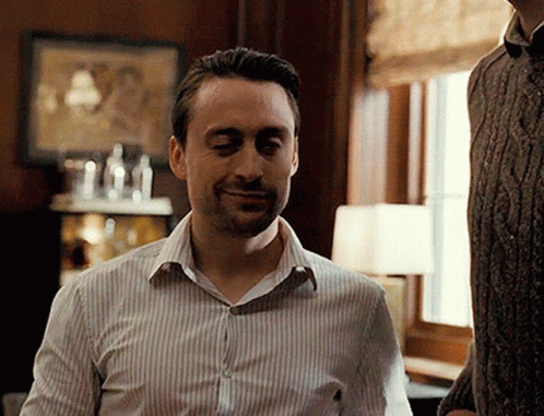 Man In Striped Shirt Smiling At Window GIF