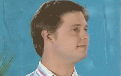 Man in Striped Shirt Smiling Blue Background
