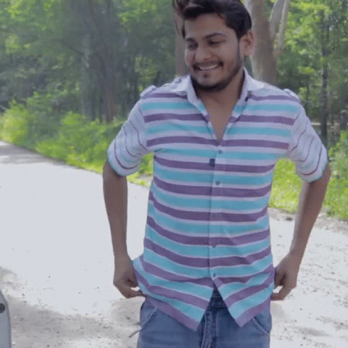 Man in Striped Shirt Smiling Holding Pockets