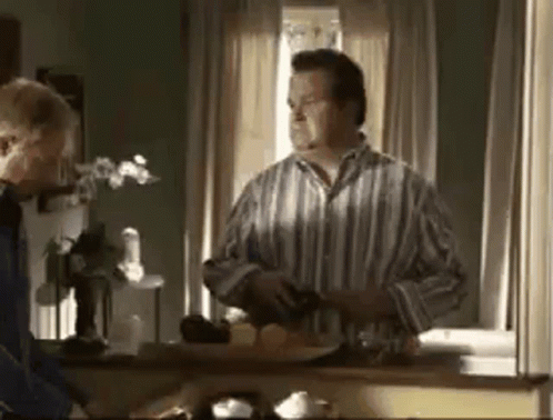Man In Striped Shirt Standing By Window GIF