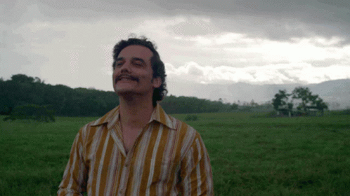 Man in Striped Shirt Standing in Field